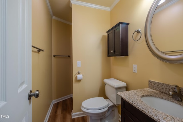 bathroom with crown molding, vanity, wood finished floors, toilet, and baseboards