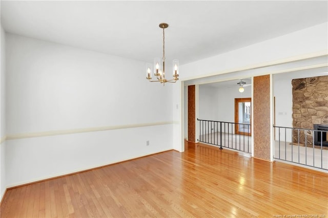 spare room featuring a chandelier and wood finished floors