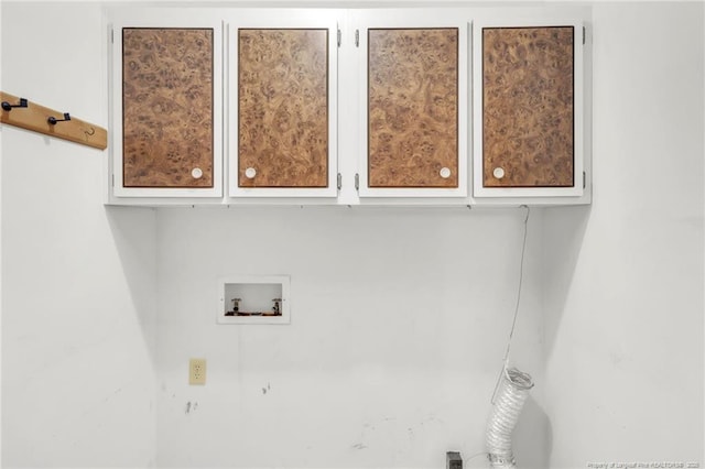 clothes washing area with hookup for a washing machine and cabinet space