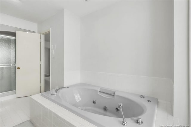 bathroom with a whirlpool tub and tile patterned flooring
