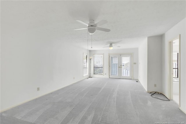 unfurnished room featuring baseboards, a ceiling fan, french doors, and light colored carpet