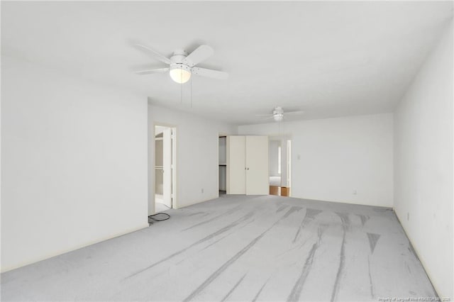 carpeted empty room featuring a ceiling fan