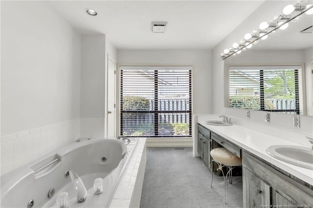 bathroom with double vanity, a whirlpool tub, and a sink
