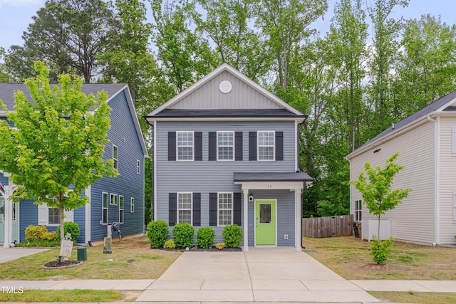 greek revival house featuring board and batten siding and fence