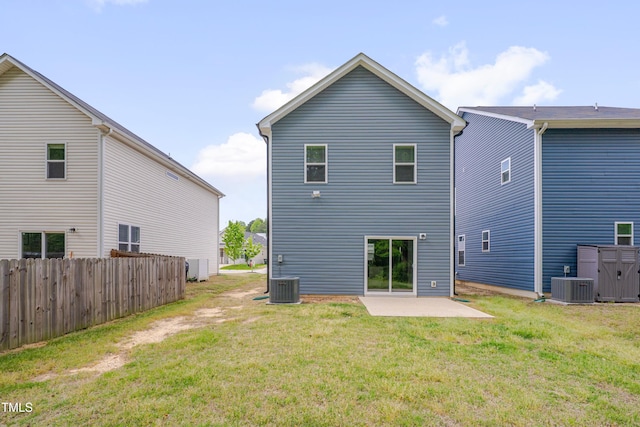 rear view of house with a lawn, fence, central air condition unit, and a patio area