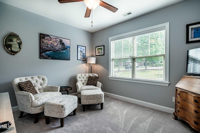 sitting room with a ceiling fan, baseboards, and carpet