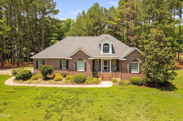 108 Cedarwood Dr, Louisburg, NC 27549 - view of front of home featuring brick siding, a porch, a front lawn, and roof with shingles