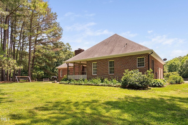 108 Cedarwood Dr, Louisburg, NC 27549 - rear view of property featuring a chimney, brick siding, a lawn, and a shingled roof