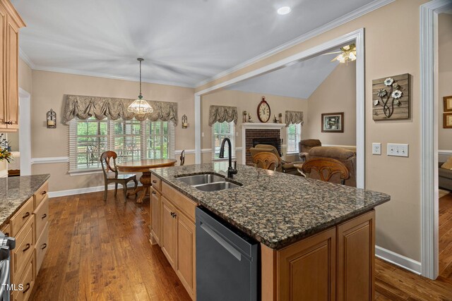 108 Cedarwood Dr, Louisburg, NC 27549 - kitchen with stainless steel dishwasher, a sink, dark wood-type flooring, a brick fireplace, and baseboards