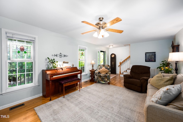 1166 NC Highway 87 N, Pittsboro, NC 27312 - living room featuring visible vents, ceiling fan, wood finished floors, and stairway