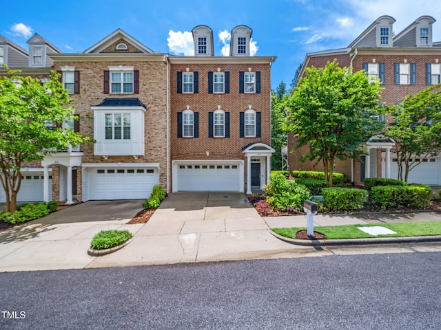 townhome / multi-family property featuring concrete driveway, brick siding, and a garage
