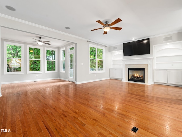 unfurnished living room with crown molding, baseboards, a ceiling fan, and a fireplace with flush hearth