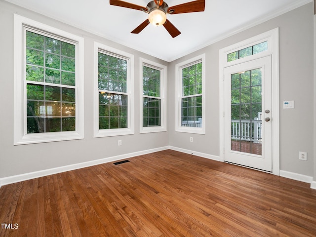 interior space featuring a deck, wood finished floors, visible vents, crown molding, and baseboards