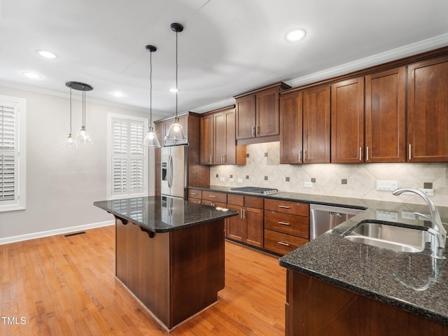 kitchen with visible vents, a sink, crown molding, decorative backsplash, and stainless steel appliances