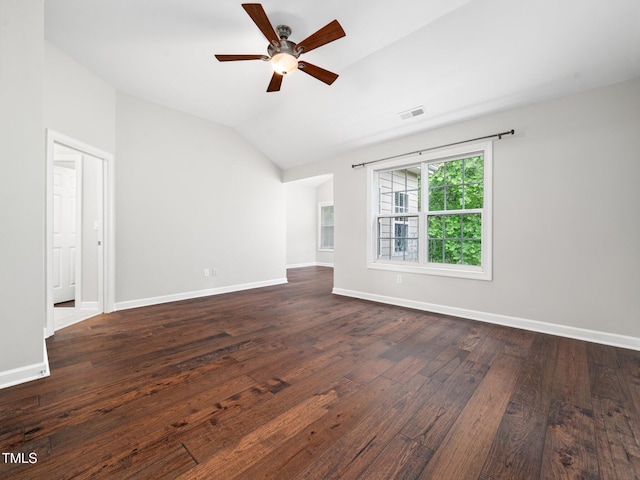 spare room with lofted ceiling, visible vents, ceiling fan, dark wood-style floors, and baseboards