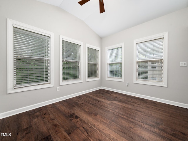 spare room with ceiling fan, lofted ceiling, baseboards, and dark wood-type flooring