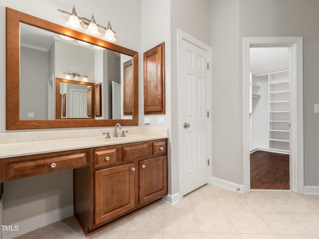 bathroom with baseboards, ornamental molding, vanity, and tile patterned flooring