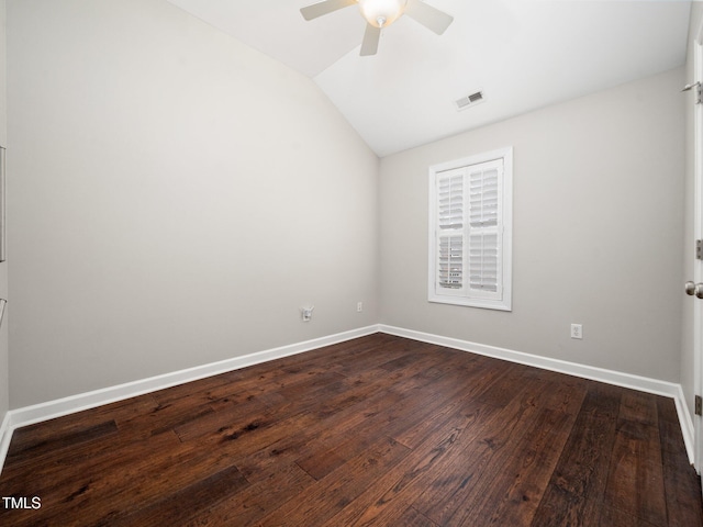 spare room featuring visible vents, baseboards, ceiling fan, vaulted ceiling, and dark wood-style floors