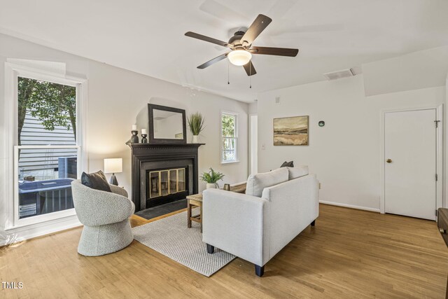 1605 Valley Run, Durham, NC 27707 - living area with light wood-style flooring, ceiling fan, a fireplace with flush hearth, and baseboards