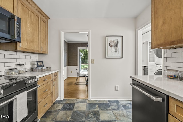 1605 Valley Run, Durham, NC 27707 - kitchen with stainless steel appliances, estacked washer and dryer, baseboards, light countertops, and decorative backsplash