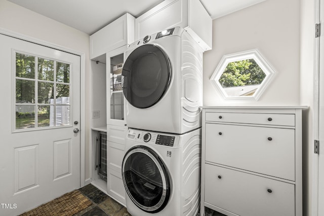 1605 Valley Run, Durham, NC 27707 - laundry room featuring stacked washer / drying machine, cabinet space, beverage cooler, dark stone finish flooring, and baseboards
