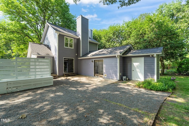 1605 Valley Run, Durham, NC 27707 - back of property with a chimney, a patio area, roof with shingles, and asphalt driveway