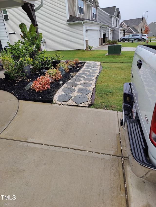 view of yard featuring driveway and an attached garage