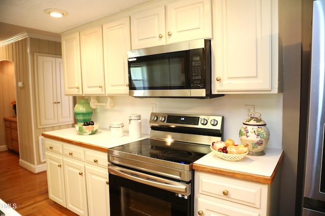 1927 Simpkins Rd, Raleigh, NC 27603 - kitchen with appliances with stainless steel finishes, light countertops, wood finished floors, and white cabinets