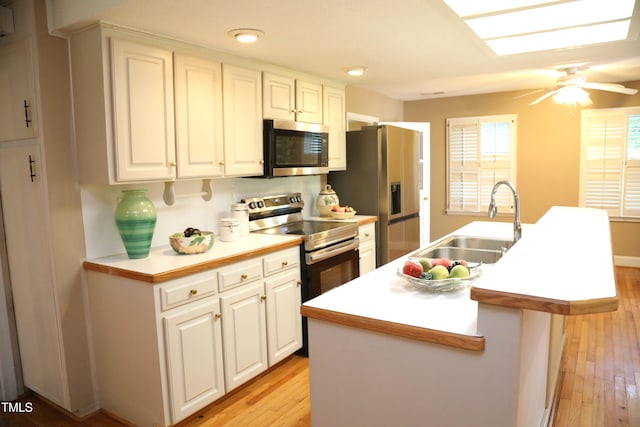 1927 Simpkins Rd, Raleigh, NC 27603 - kitchen featuring stainless steel appliances, light wood-style floors, a kitchen island with sink, white cabinetry, and recessed lighting
