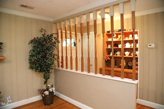 1927 Simpkins Rd, Raleigh, NC 27603 - wine room featuring wood finished floors, ornamental molding, and a textured ceiling