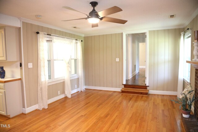 1927 Simpkins Rd, Raleigh, NC 27603 - unfurnished living room with light wood-type flooring, plenty of natural light, and crown molding
