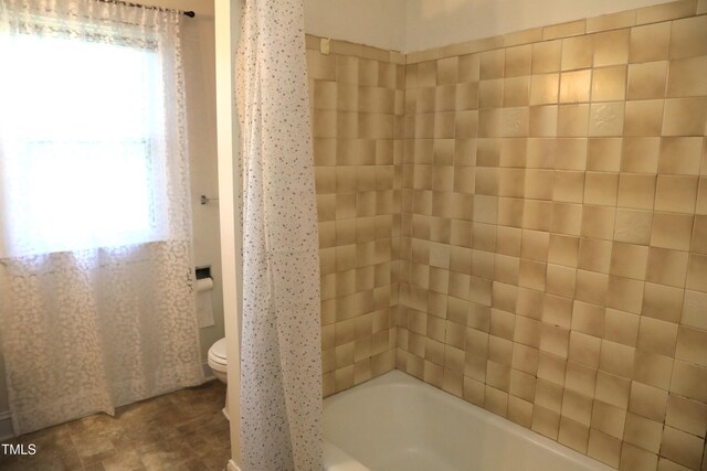 1927 Simpkins Rd, Raleigh, NC 27603 - bathroom featuring healthy amount of natural light and shower / bath combo with shower curtain