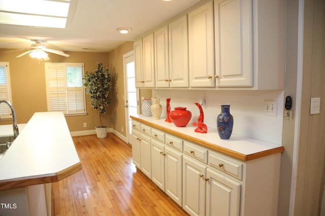 1927 Simpkins Rd, Raleigh, NC 27603 - kitchen featuring light countertops, light wood-type flooring, and white cabinetry