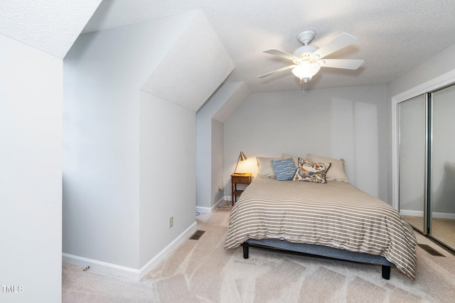 bedroom featuring a ceiling fan, a textured ceiling, visible vents, a closet, and carpet flooring