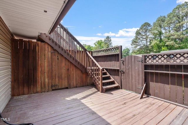 deck featuring fence, a gate, and stairs