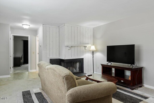 living area with a large fireplace, baseboards, and light carpet