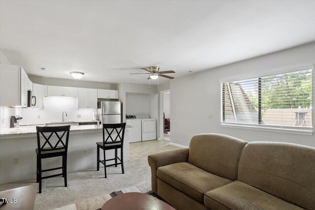 living room featuring ceiling fan and washing machine and clothes dryer