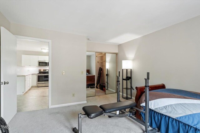 bedroom featuring baseboards, light colored carpet, and a closet