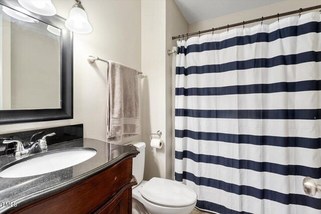 bathroom featuring vanity, curtained shower, and toilet