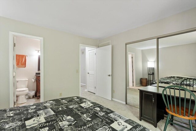 bedroom featuring light carpet, a closet, and connected bathroom