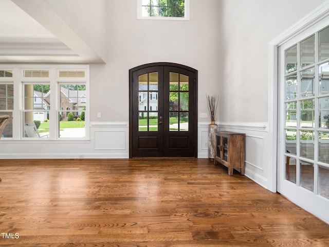 12424 Beauvoir St, Raleigh, NC 27614 - entryway featuring healthy amount of natural light, wainscoting, arched walkways, a decorative wall, and wood finished floors