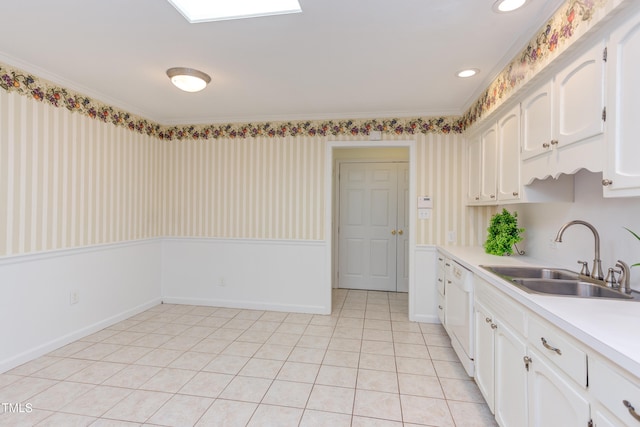 kitchen with white dishwasher, light countertops, white cabinets, a sink, and light tile patterned floors
