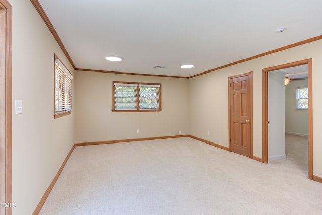 spare room featuring crown molding, recessed lighting, baseboards, and light colored carpet