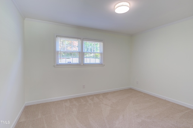 carpeted empty room featuring baseboards and ornamental molding