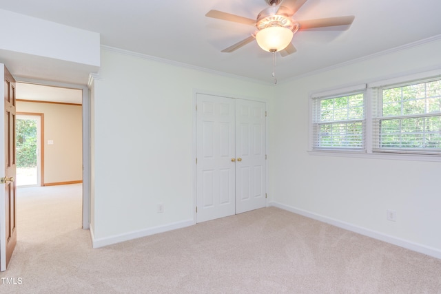 unfurnished bedroom with baseboards, light colored carpet, and a closet