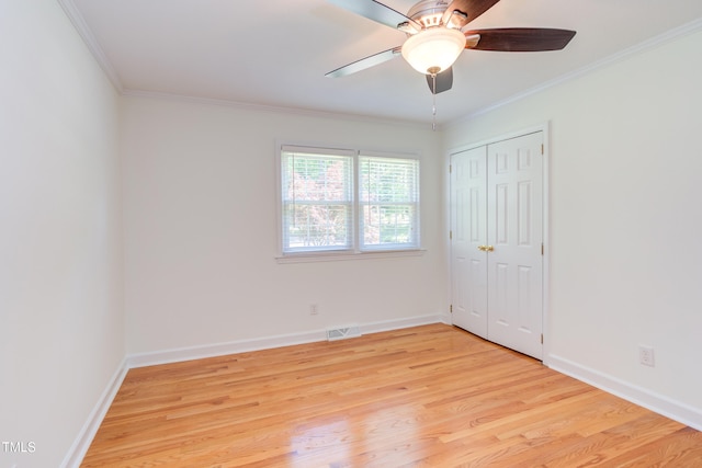 unfurnished bedroom featuring baseboards, ornamental molding, light wood-type flooring, and visible vents