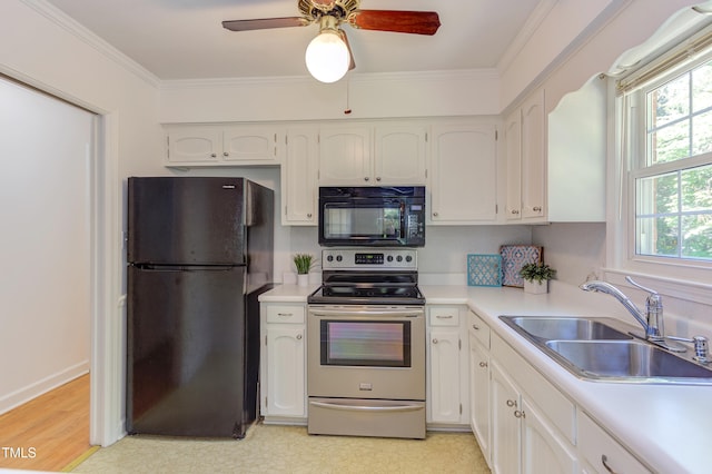 kitchen featuring crown molding, a sink, light countertops, black appliances, and white cabinetry