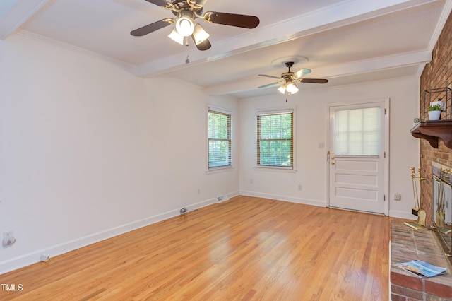 unfurnished living room with a ceiling fan, a brick fireplace, beam ceiling, baseboards, and light wood finished floors