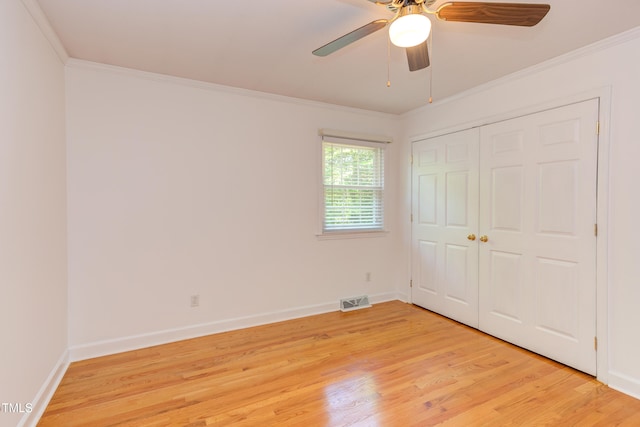 unfurnished bedroom with visible vents, ornamental molding, light wood-style flooring, and baseboards