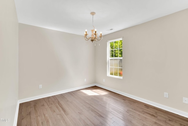 105 N 11th St, Erwin, NC 28339 - spare room with baseboards, visible vents, wood finished floors, and a notable chandelier